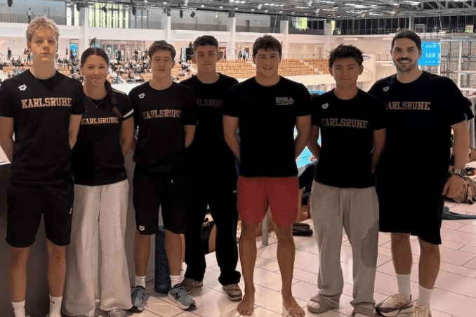 Gruppe von sechs Schwimmern in Schwarz mit "Karlsruhe"-Aufdruck, stehend in einem Schwimmbad bei der DM 2026.